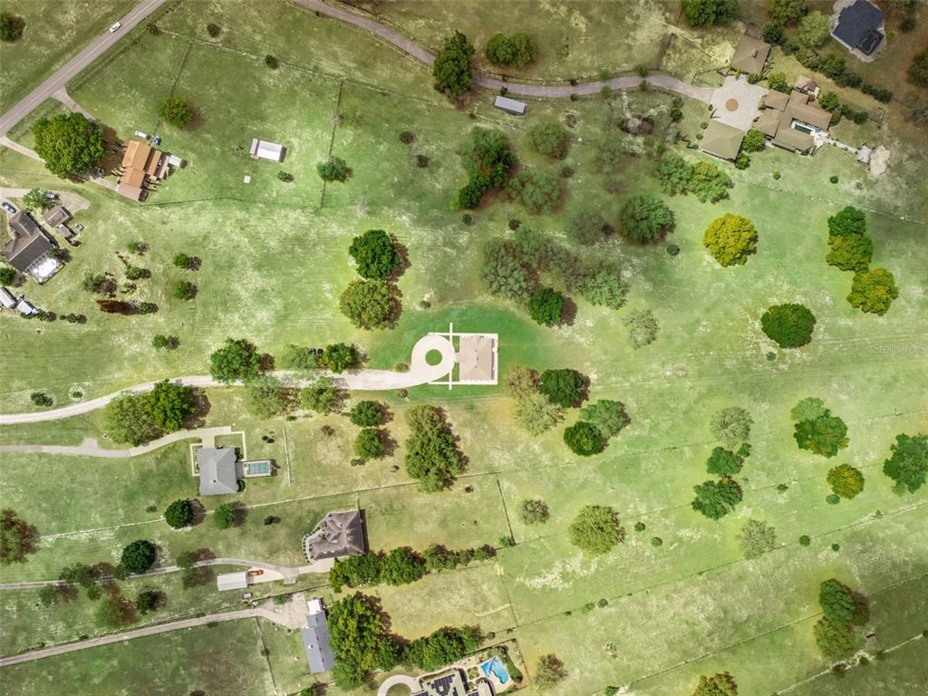 An aerial view shows several houses with driveways and pools scattered across a large grassy lot — 11155 CHERRY LAKE ROAD, CLERMONT, FL