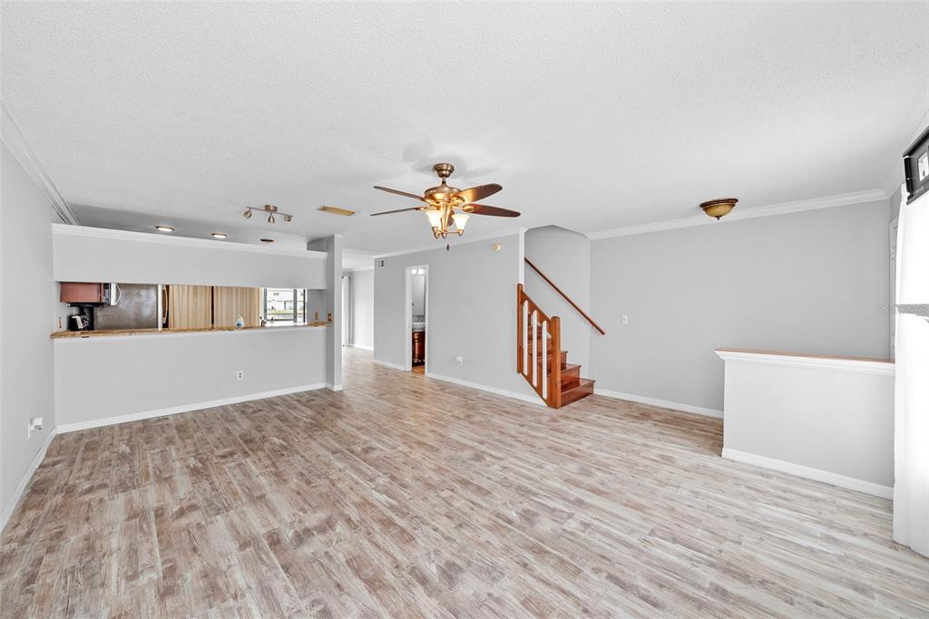 A bedroom with hardwood floors, a ceiling fan, a wall-mounted television, and an attached bathroom — 5314 ABINGER COURT, TAMPA, FL