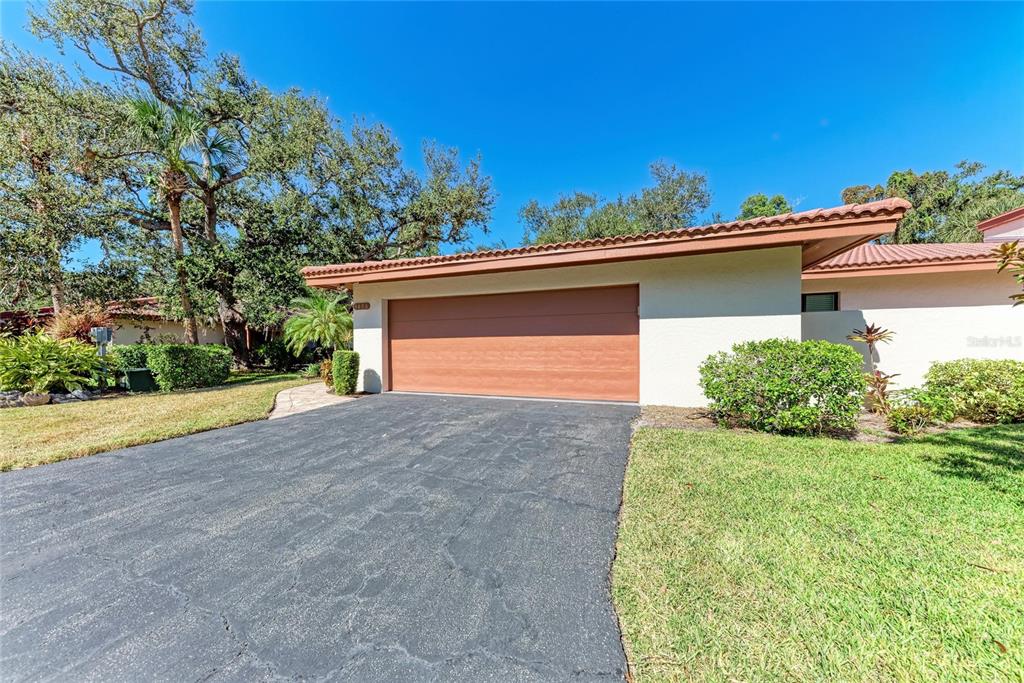 A view of a house exterior featuring a brown garage door and an asphalt driveway — 3406 FALCON PLACE, BRADENTON, FL
