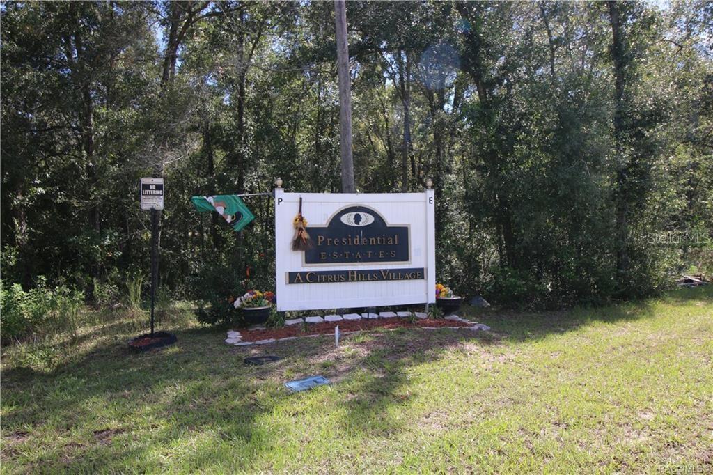 A sign for Presidential Estates at Citrus Hills Village stands in a wooded area — 1012 E MCKINLEY STREET, HERNANDO, FL