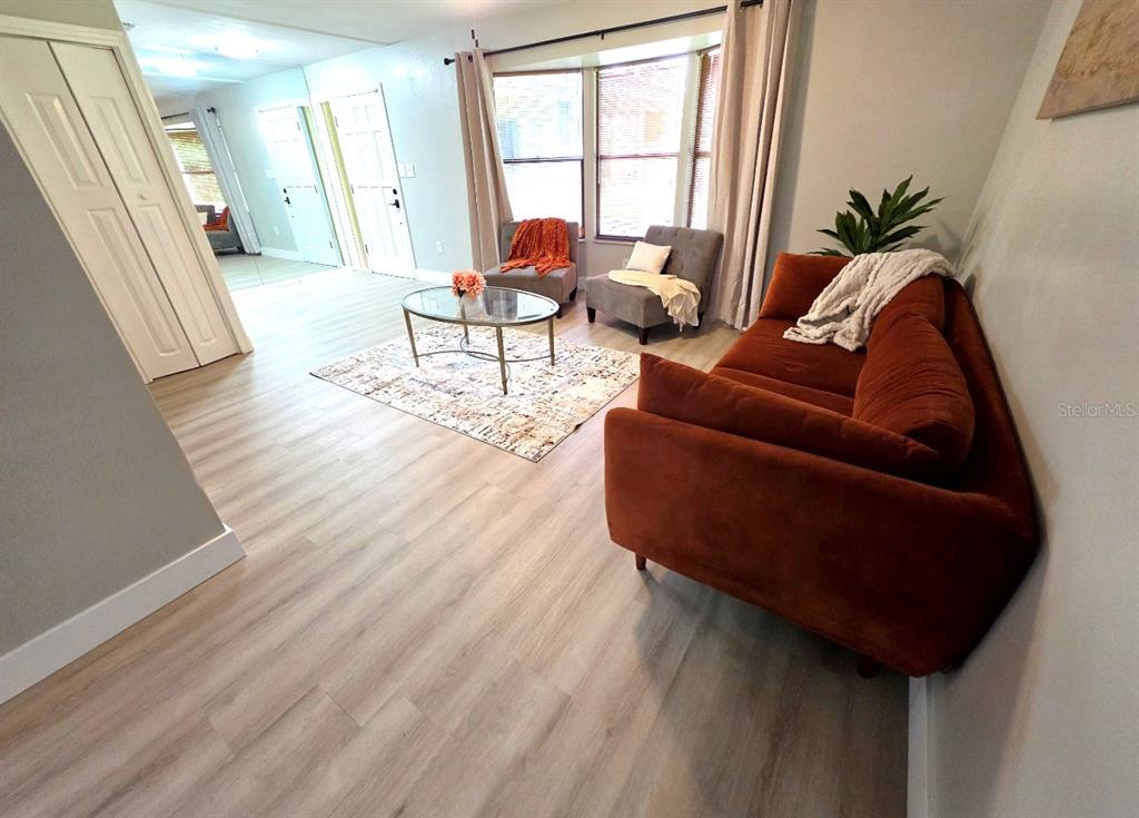 A bright kitchen features white cabinets, granite countertops, a central island, and light wood flooring — 162 W MASSACHUSETTS STREET, HERNANDO, FL