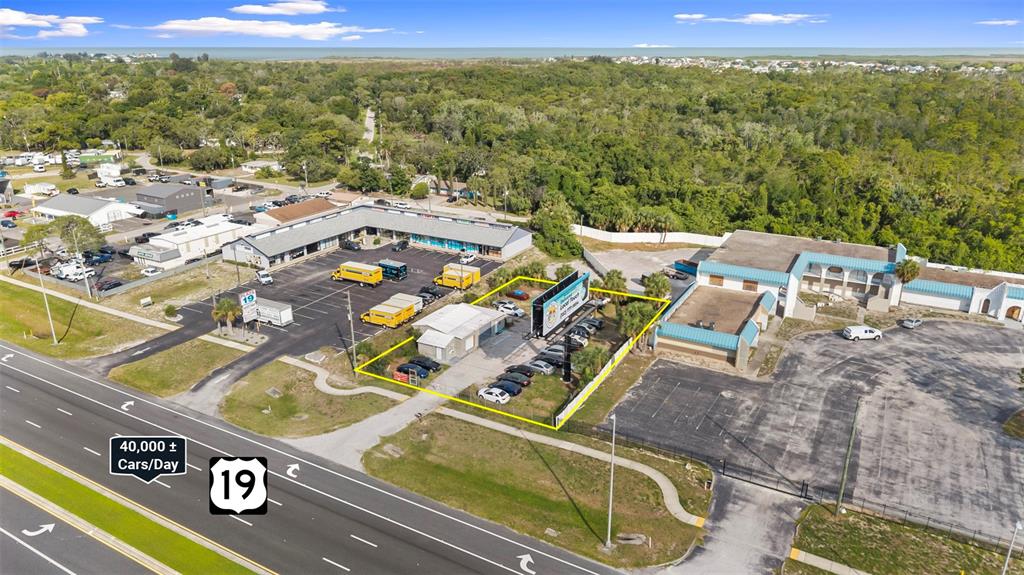 An aerial view shows a commercial property with a parking lot along a highway — 15217 US HIGHWAY 19, HUDSON, FL