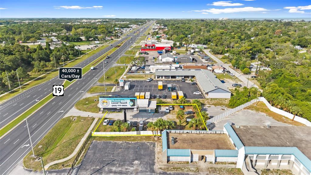 An aerial view shows a commercial property with a billboard located beside a highway — 15217 US HIGHWAY 19, HUDSON, FL