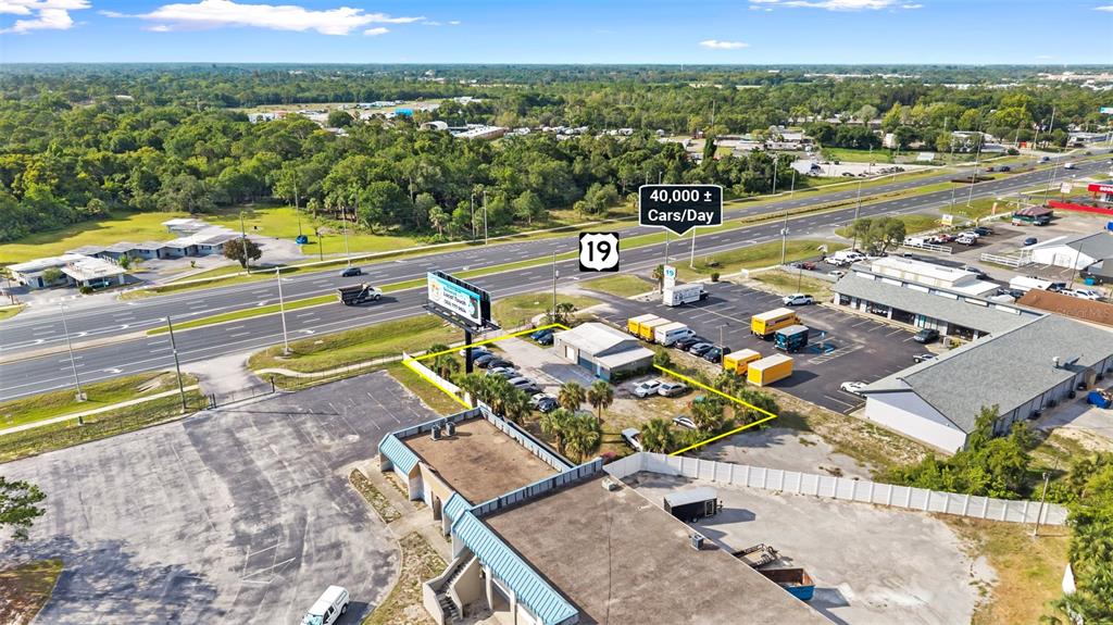 An aerial view shows a commercial property with a parking lot along a highway — 15217 US HIGHWAY 19, HUDSON, FL