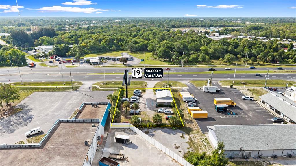 An aerial view shows a commercial property outlined in yellow along a busy highway — 15217 US HIGHWAY 19, HUDSON, FL