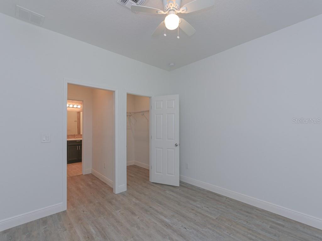 A bathroom features a double vanity with dark gray cabinets and a wood-look tile backsplash — 2831 W LIVINGSTON STREET, ORLANDO, FL