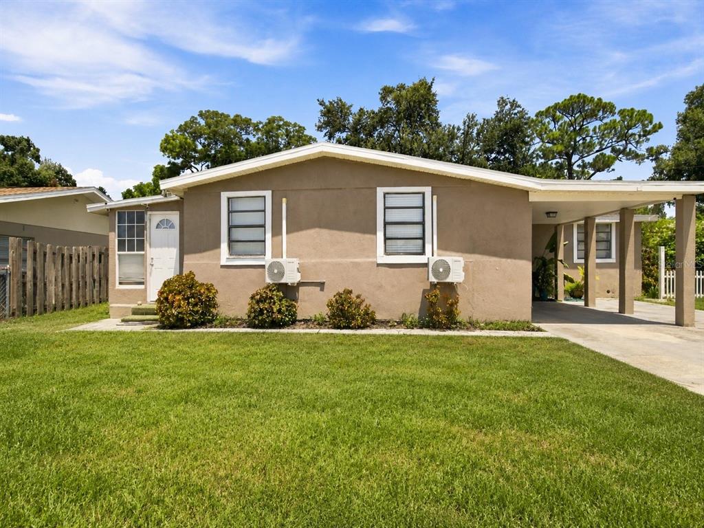 A single-story house with a tan stucco exterior, two windows, and an attached carport — 603 60TH AVENUE W, BRADENTON, FL