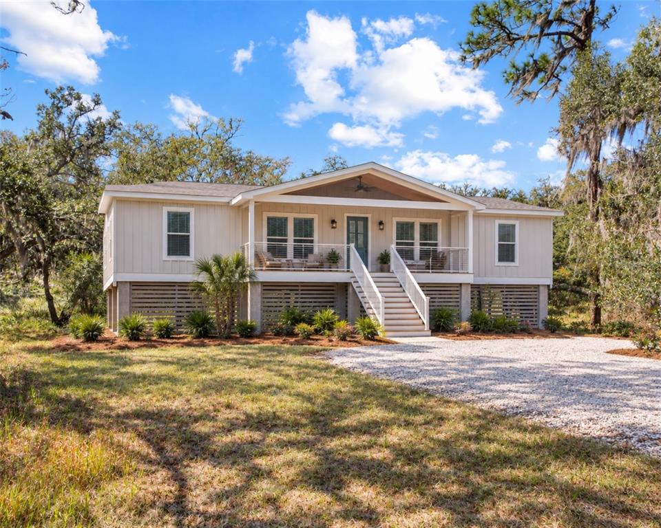 A weathered wooden pergola stands in a grassy, overgrown lot shaded by large oak trees — 12111 FRED DRIVE, RIVERVIEW, FL