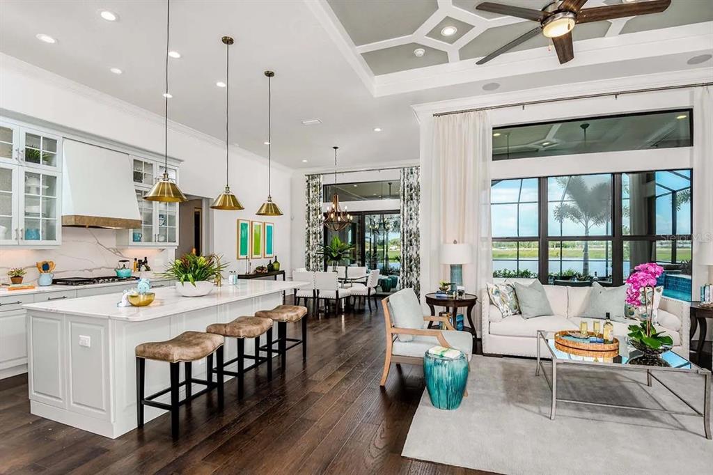 A kitchen with a large white marble island, light blue cabinetry, and brass pendant lights — 332 BOCELLI DRIVE, NORTH VENICE, FL