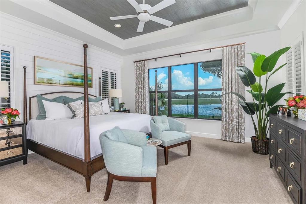 An open-concept kitchen and living area features a large island, hardwood floors, and floor-to-ceiling windows — 332 BOCELLI DRIVE, NORTH VENICE, FL