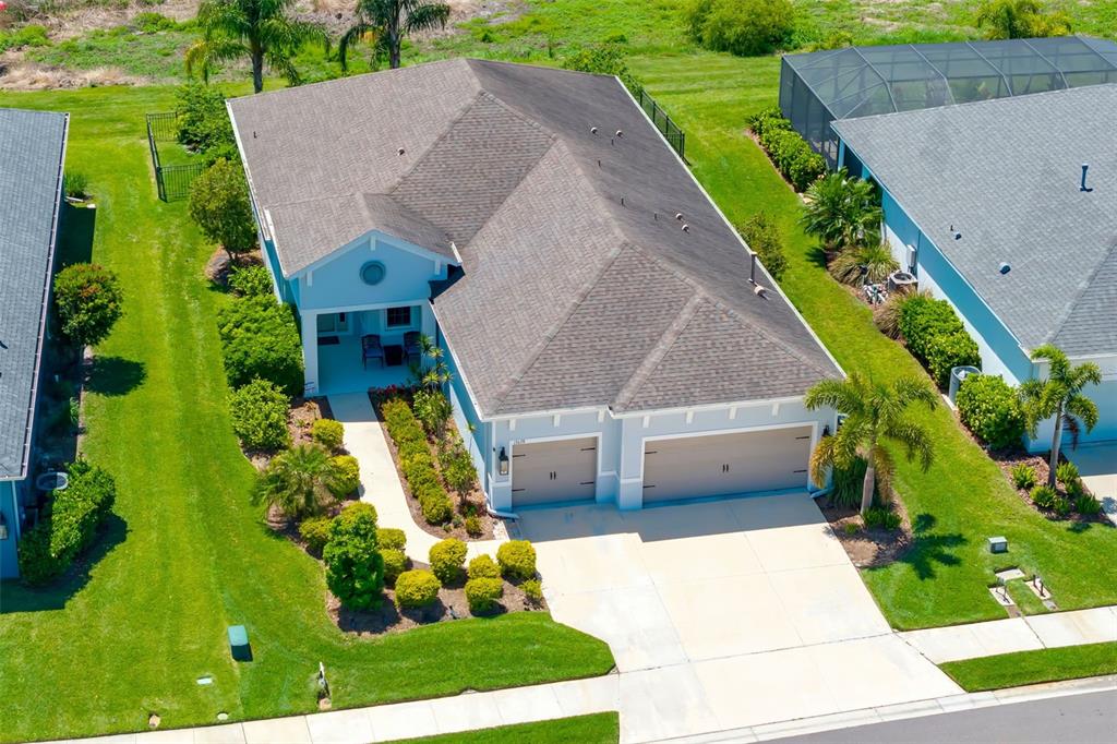 An aerial view shows a single-story house with a two-car garage and landscaped front yard — 13638 OLD CREEK CT, PARRISH, FL