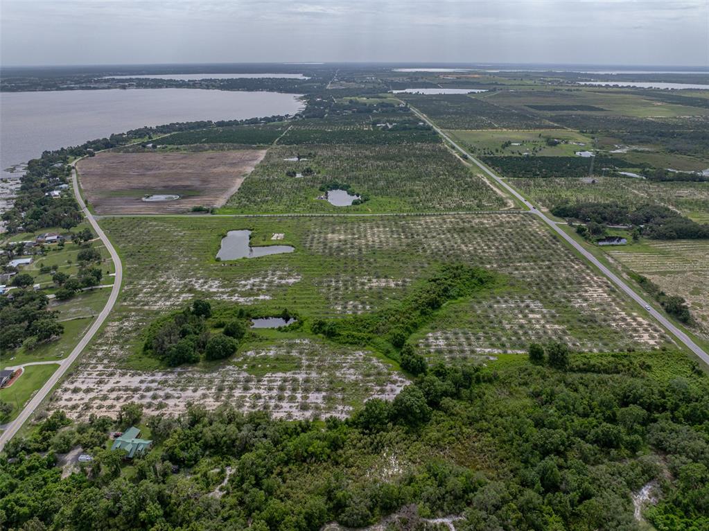 An aerial view shows a large, flat plot of land with scattered ponds and trees — 0 BARR ROAD, FROSTPROOF, FL
