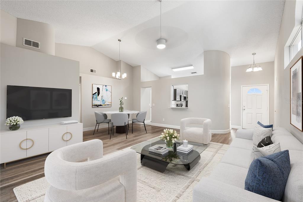 A bright living room features white furniture, a glass coffee table, and a dining area — 4011 LEVONSHIRE PLACE, VALRICO, FL