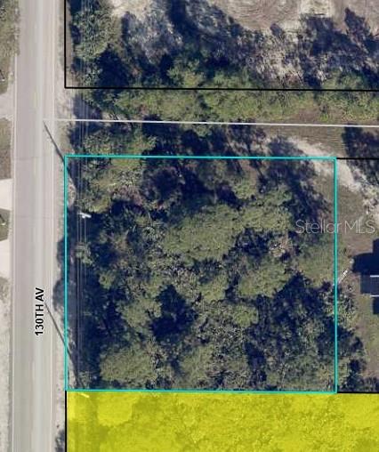 An aerial map view shows a rectangular, wooded vacant lot bordering a paved road — 8590 130TH AVENUE, FELLSMERE, FL
