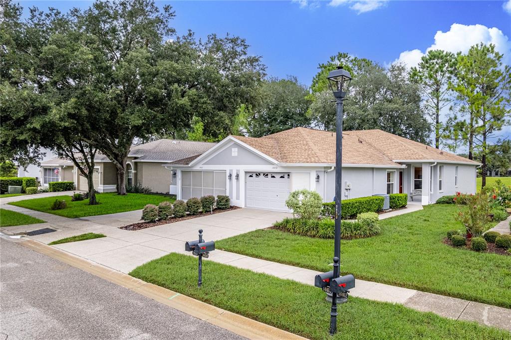 A single-story suburban house with a gray exterior, tan roof, and a two-car garage — 14459 STERLING RUN, SPRING HILL, FL
