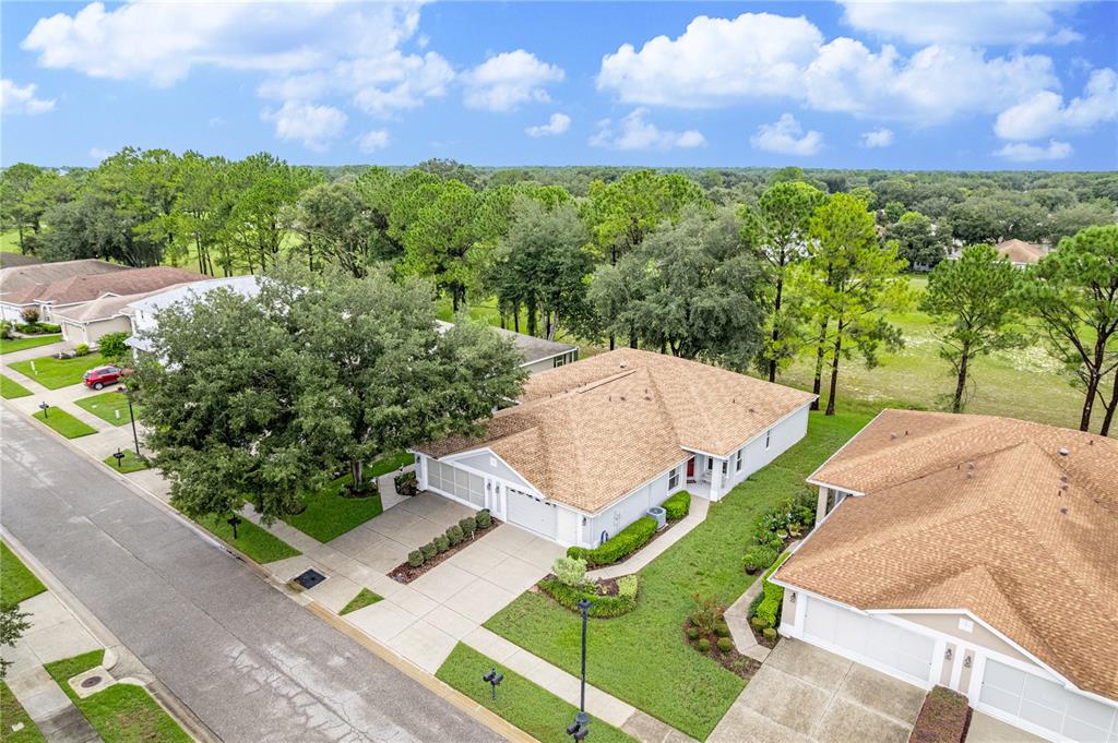 An aerial view shows a suburban house with a tan roof and a concrete driveway — 14459 STERLING RUN, SPRING HILL, FL