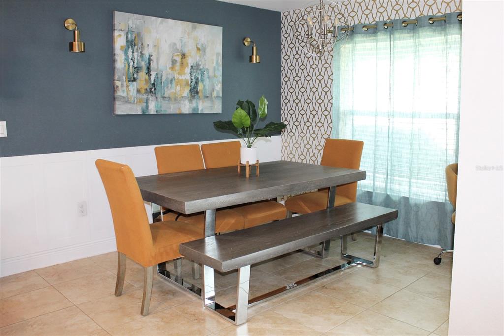 A dining room features a gray table, a bench, mustard chairs, and a blue accent wall — 826 LANDMARK HILLS DRIVE, HAINES CITY, FL