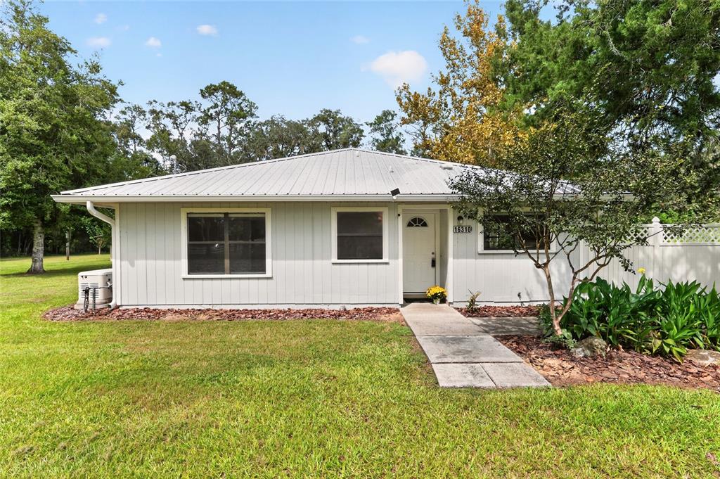 A dirt driveway leads through a grassy field lined with trees and a white fence — 16310 NW 40TH PLACE, NEWBERRY, FL