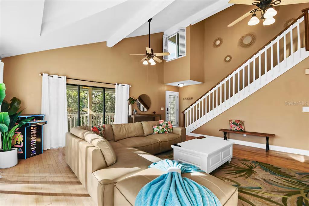 A living room features a tan sectional sofa, a white coffee table, and a staircase — 13837 76TH AVENUE, SEMINOLE, FL