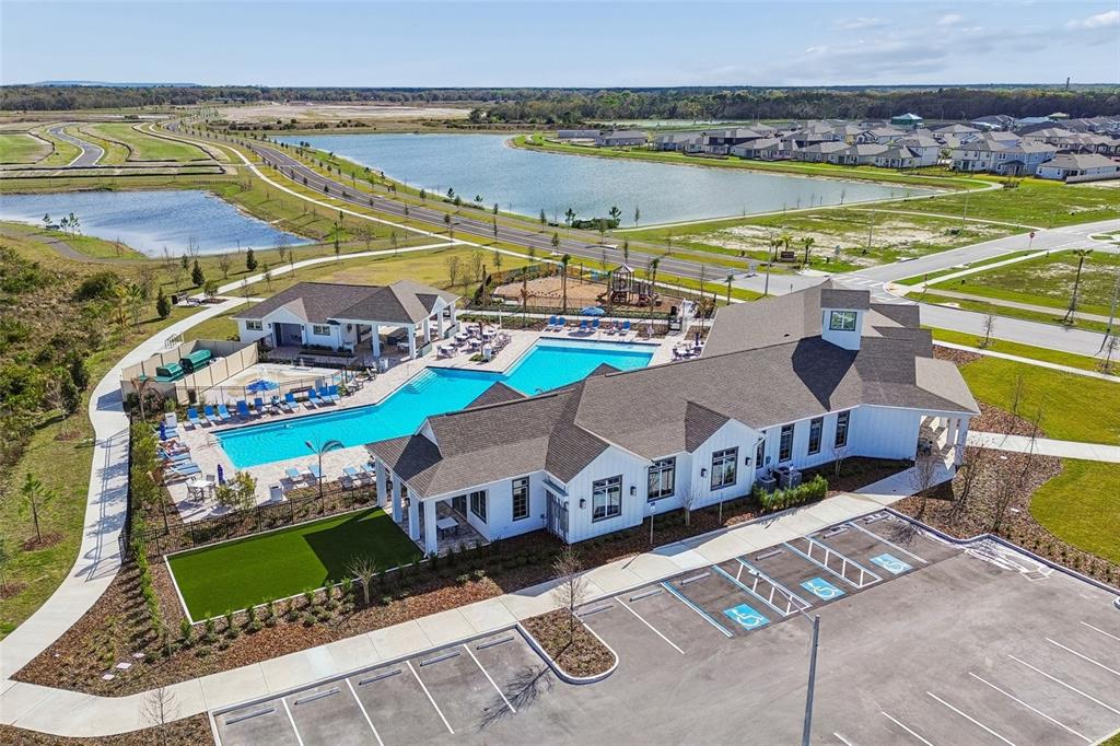 An aerial view shows a community clubhouse with a swimming pool and parking lot — 5801 FREESIA DRIVE, LAKELAND, FL