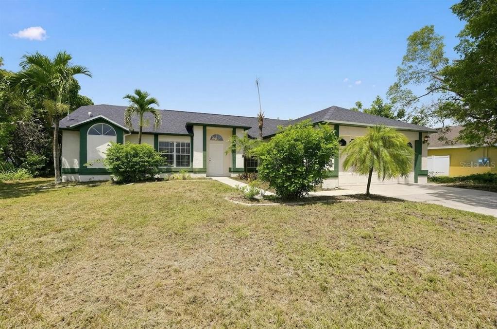 A single-story house with a white exterior, green trim, and a front-facing garage — 1325 SW 25TH TERRACE, CAPE CORAL, FL