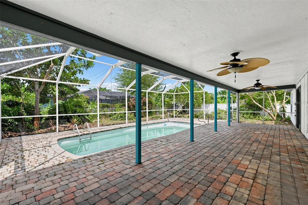 A covered brick patio features a swimming pool enclosed by a screened-in lanai structure — 1325 SW 25TH TERRACE, CAPE CORAL, FL