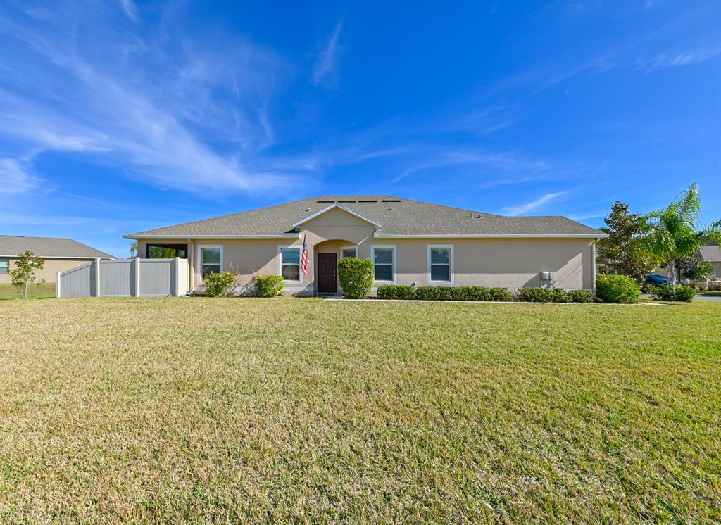 A single-story house with a beige stucco exterior, a gray shingled roof, and a lawn — 13529 CREST LAKE DR, HUDSON, FL