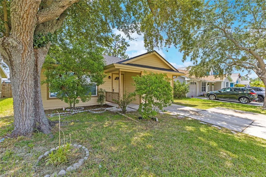 A single-story house with tan siding, a front porch, and a large tree in front — 9148 DUBOIS BOULEVARD, ORLANDO, FL