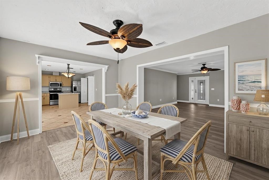 A dining room with a wooden table, striped chairs, and a ceiling fan — 1304 71ST STREET NW, BRADENTON, FL