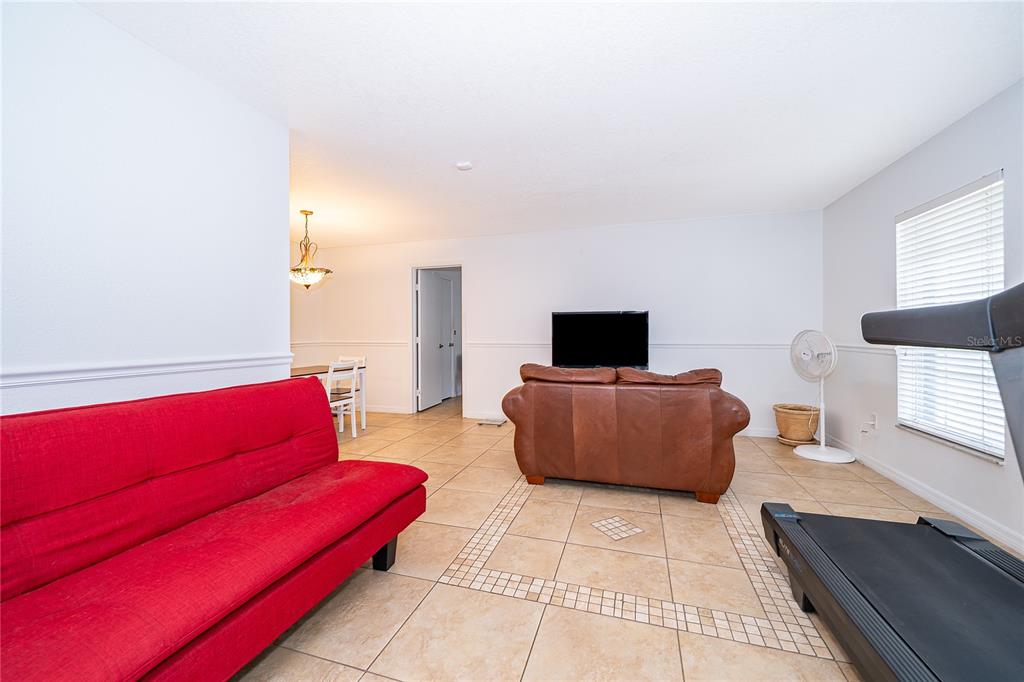 A kitchen with wood cabinets, granite countertops, tile flooring, and a white stove — 103 KILKENNY COURT, LONGWOOD, FL