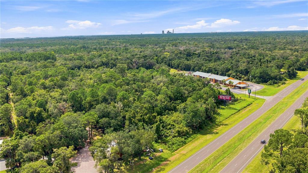 An aerial view shows a wooded lot next to a highway and a commercial building — 4366 N SUNCOAST BOULEVARD, CRYSTAL RIVER, FL