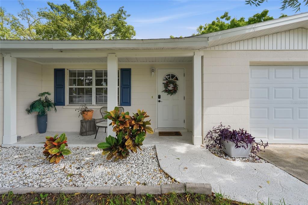 A single-story house with white siding, a front porch, and an attached garage under trees — 5008 27TH AVENUE W, BRADENTON, FL