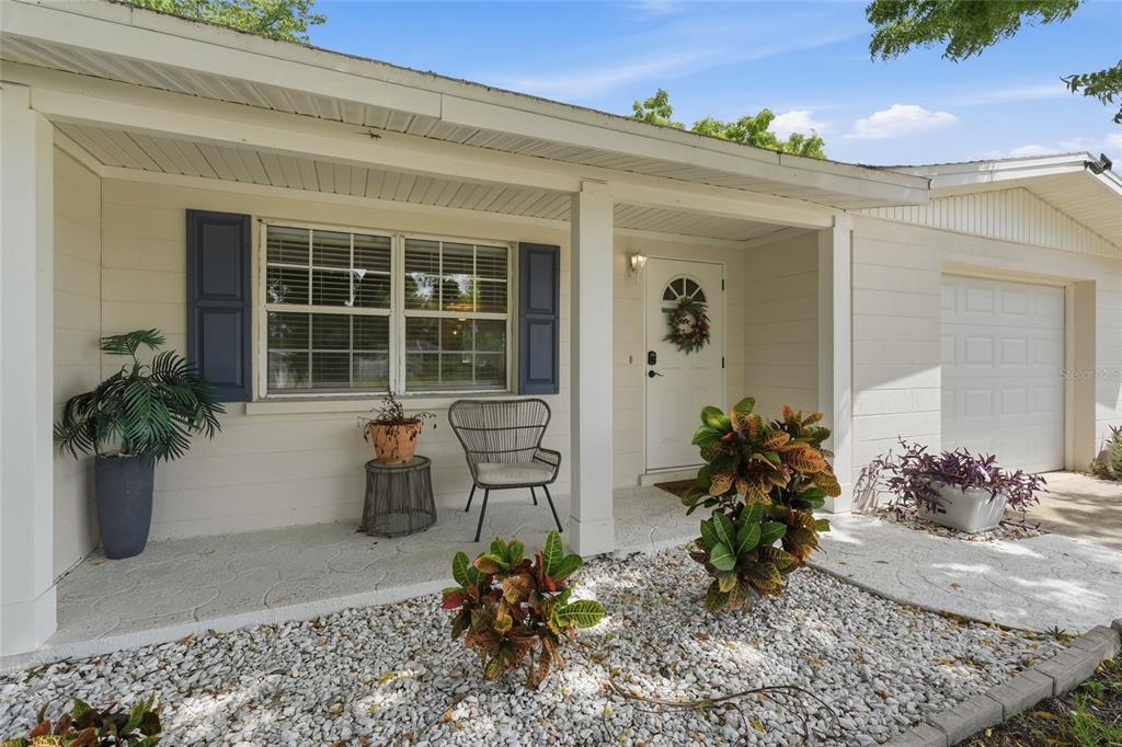 A living room features a beige sofa, two side tables with lamps, and a coffee table — 5008 27TH AVENUE W, BRADENTON, FL