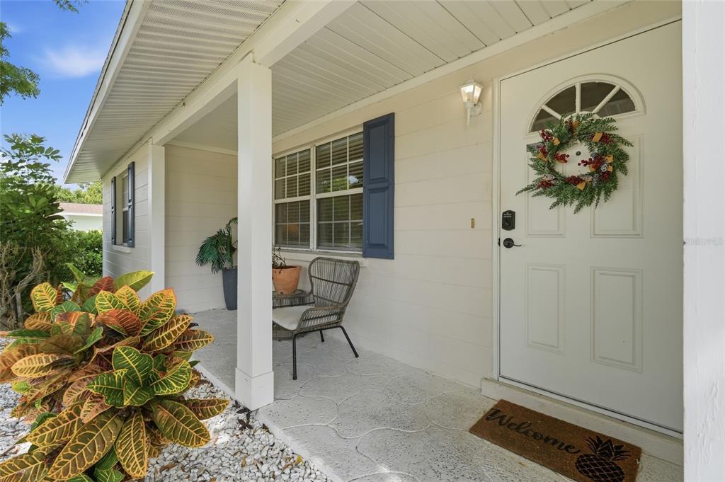 A living room with carpet, a blue recliner, and a dining area in the background — 5008 27TH AVENUE W, BRADENTON, FL
