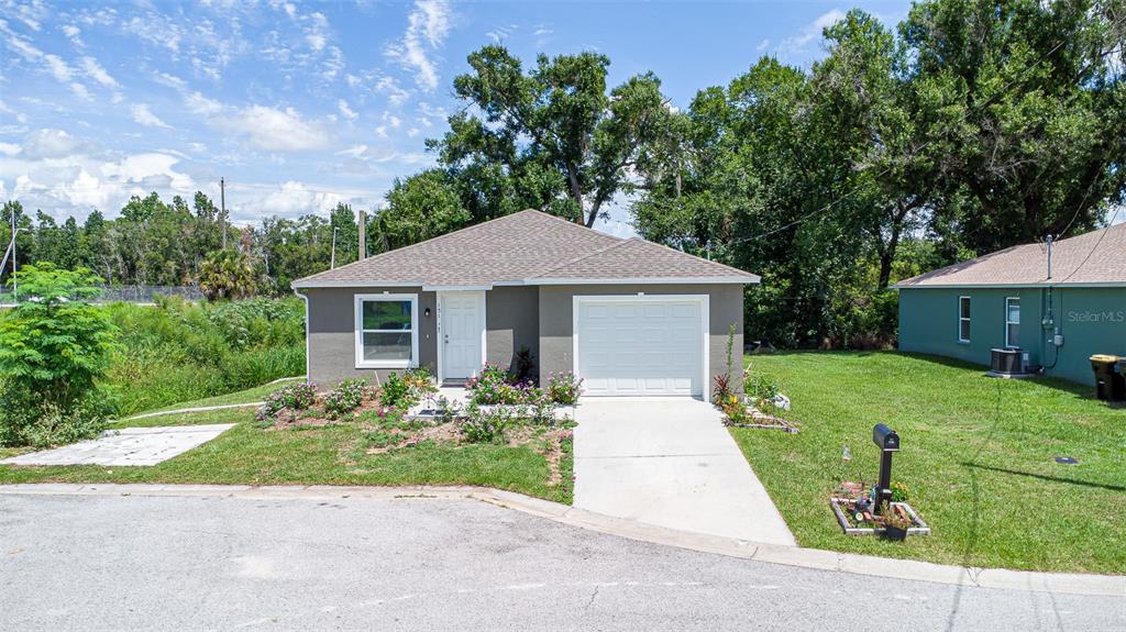 A grassy backyard features a metal storage shed, banana plants, and large mature trees — 151 1ST STREET, WINTER HAVEN, FL