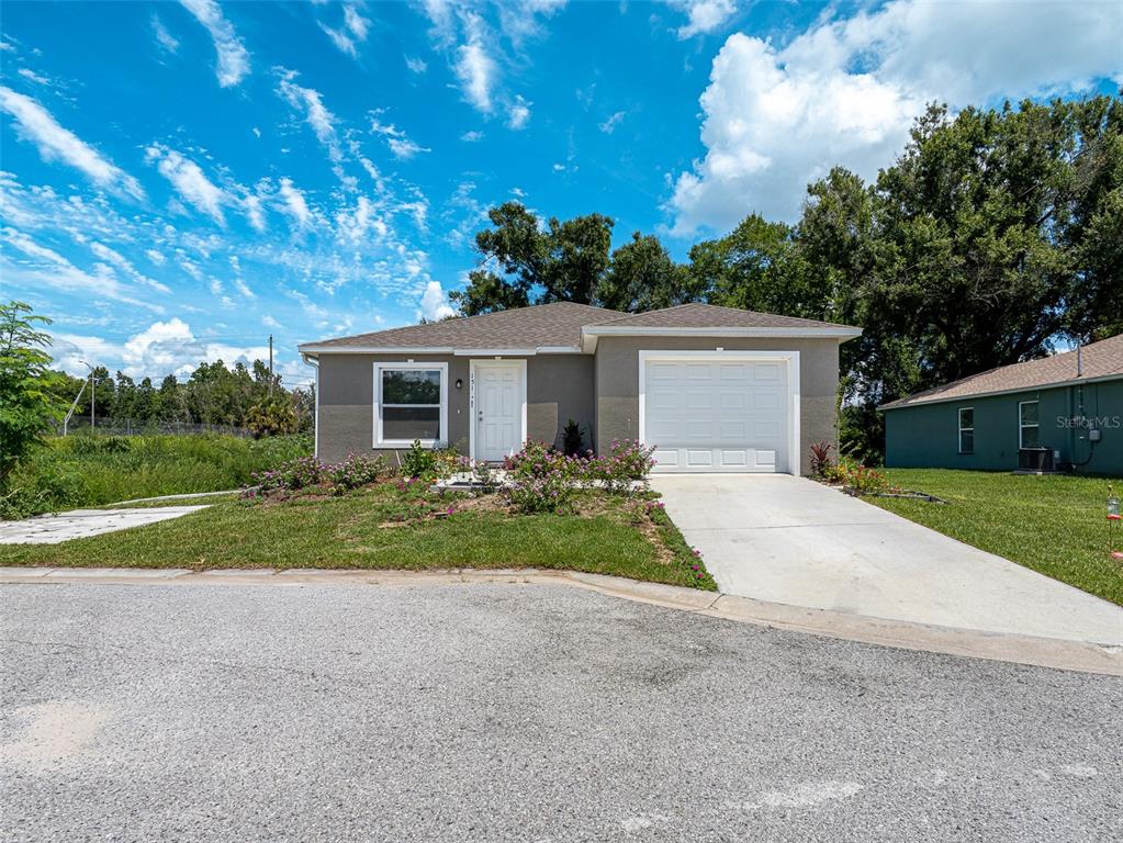 A single-story house with a gray exterior, a white garage door, and a front lawn — 151 1ST STREET, WINTER HAVEN, FL