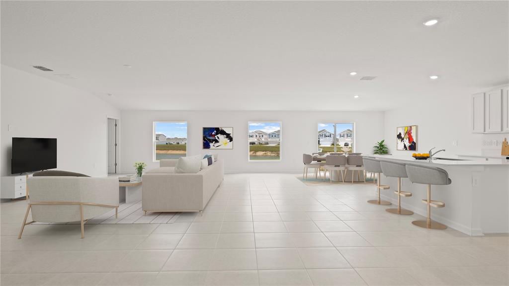 This is a digital rendering of an open-concept living area with tile floors and kitchen island — 2085 LASSO LOOP, EAGLE LAKE, FL