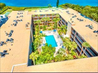 An aerial view of a multi-story apartment complex surrounding a central courtyard with a pool — 12760 INDIAN ROCKS ROAD UNIT 903, LARGO, FL