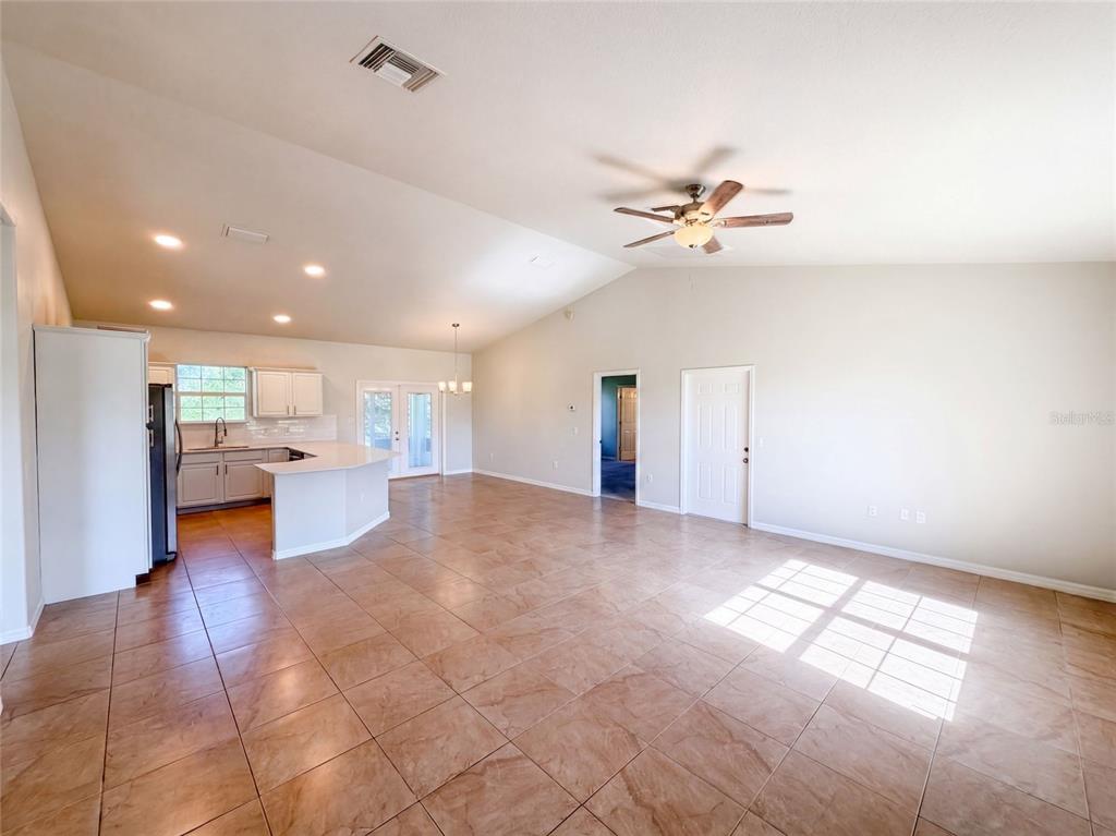 An open-concept living area features a kitchen with white cabinets and tile flooring throughout — 2925 N LOWELL ROAD, AVON PARK, FL