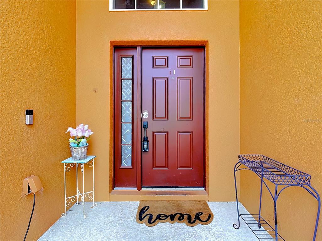 A front entryway features a red door with a sidelight, a welcome mat, and furniture — 206 VIOLA DRIVE, DAVENPORT, FL