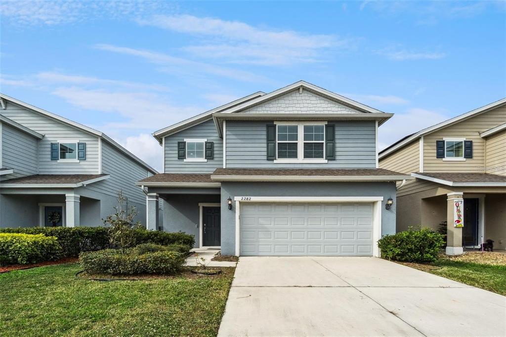 A two-story house with blue siding, a two-car garage, and a concrete driveway — 2282 NUTHATCH STREET, ST CLOUD, FL