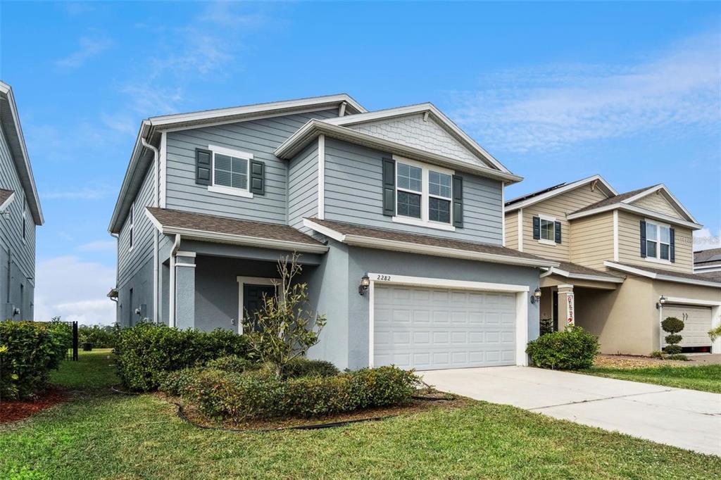 A two-story blue house with a two-car garage and a small front yard — 2282 NUTHATCH STREET, ST CLOUD, FL