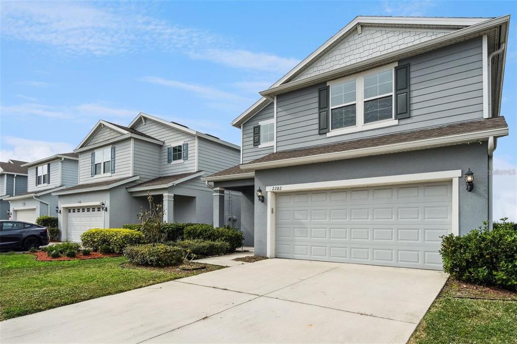 A two-story house with gray siding, a concrete driveway, and a two-car garage — 2282 NUTHATCH STREET, ST CLOUD, FL