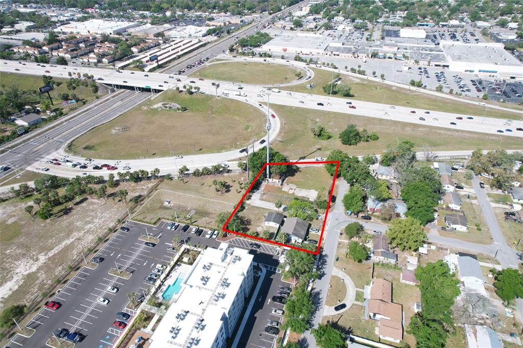 An aerial view shows a rectangular property outlined in red next to a highway interchange — 705 E WILMA STREET, TAMPA, FL