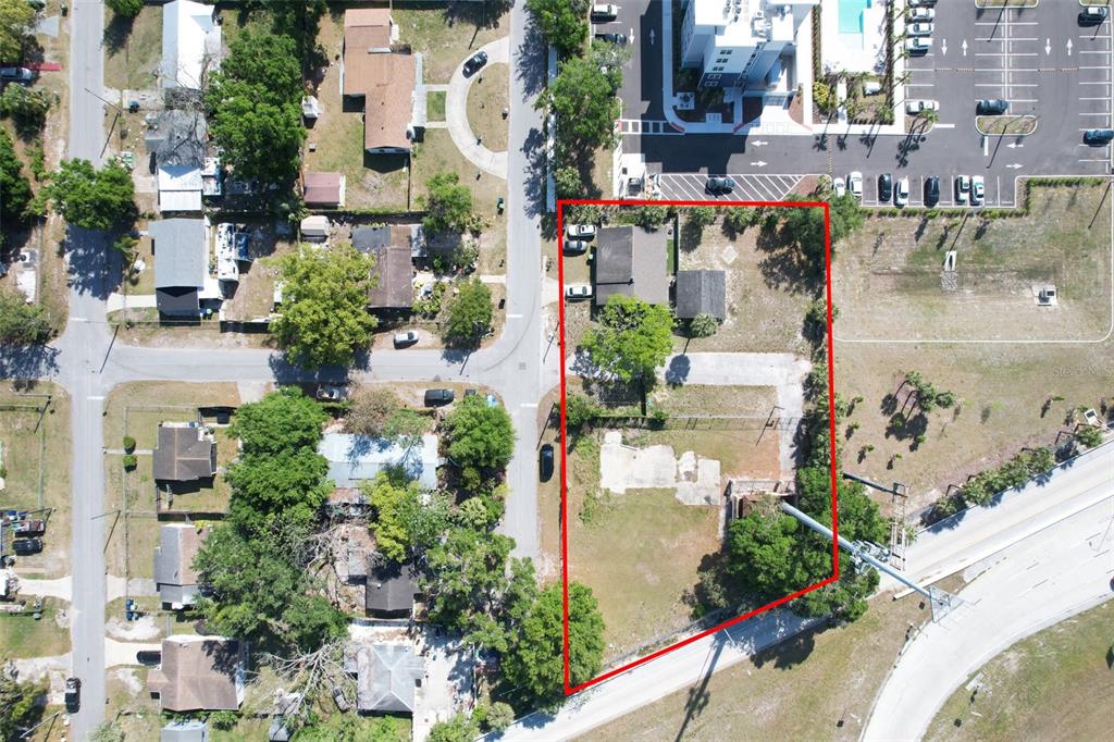 An aerial view shows a rectangular property lot outlined in red with a house and foundation — 705 E WILMA STREET, TAMPA, FL