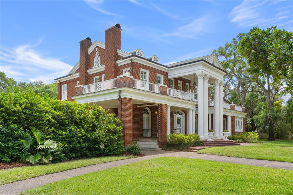 A brick exterior of a two-story home features a columned porch and arched doorways — 1760 OLD EAGLE LAKE ROAD, BARTOW, FL
