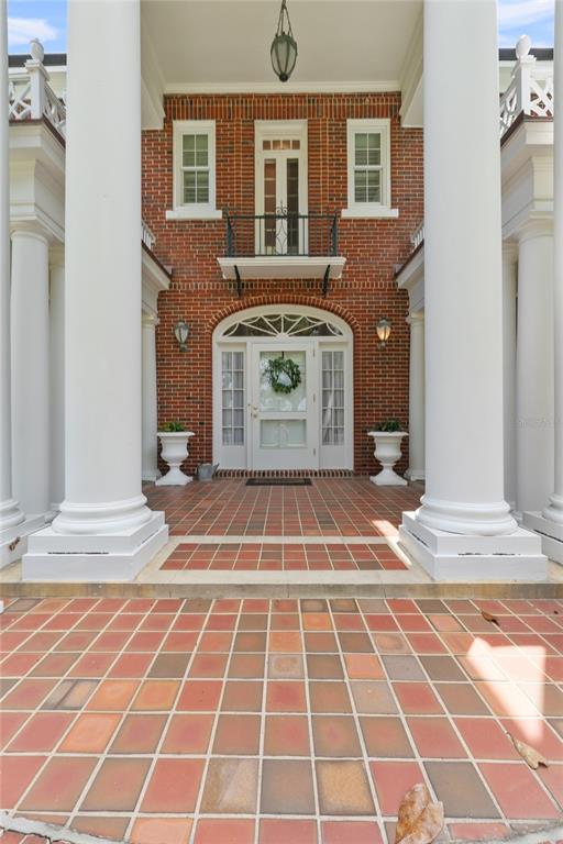 A foyer with yellow walls, a crystal chandelier, a round wooden table, and arched doorways — 1760 OLD EAGLE LAKE ROAD, BARTOW, FL