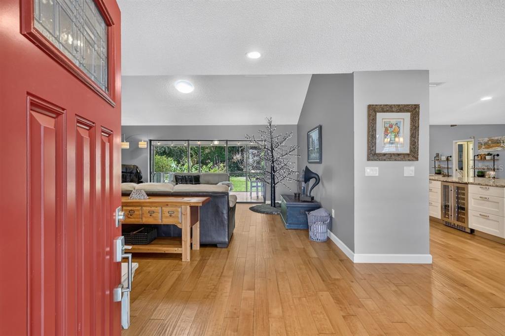 A view from a red front door into a living room with hardwood floors — 4395 OAK VIEW DRIVE, SARASOTA, FL