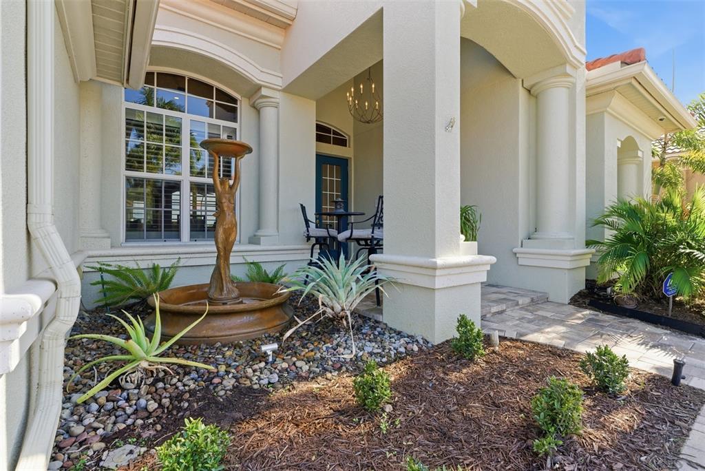 A front entryway features a bronze fountain, a blue door, and a paved walkway — 120 12TH AVENUE E, PALMETTO, FL