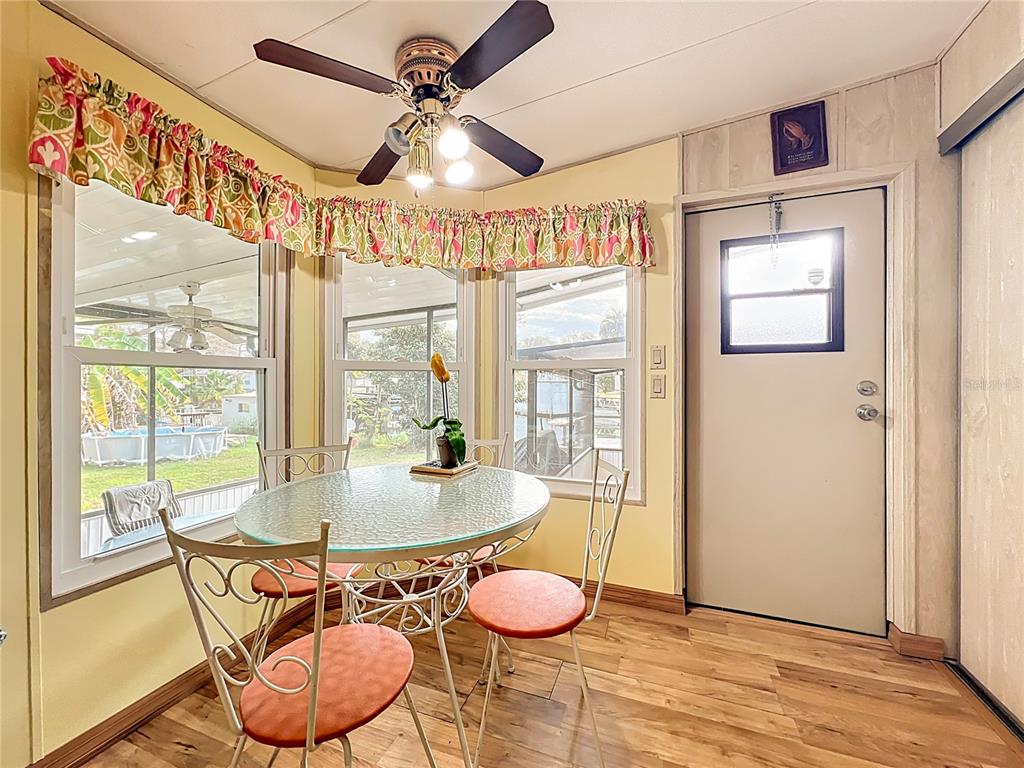 A green mobile home features a concrete carport, a screened-in porch, and a small garden — 13508 PALM DRIVE, ASTATULA, FL